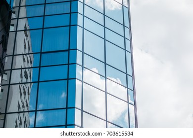 glass facade of skyscraper at germany with cloud reflections