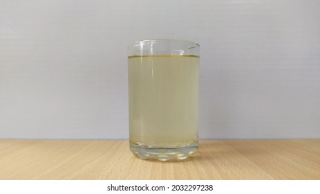 Glass Filled With Undrinkable, Unhealthy And Unhygienic Dirty Drinking Water On A Table With White Background And Copy Space. Photo About Water Shortage In Africa, Asia, Ethiopia, Nigeria And India.