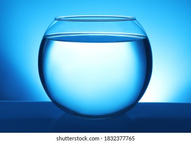 Glass Fish Bowl With Clear Water On Blue Background