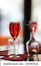 Glass with French alcohol drink Kir Royal on the table at the restaurant 