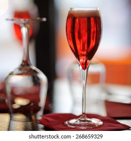 Glass with French alcohol drink Kir Royal on the table at the restaurant
