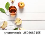 Glass of fresh apple juice on white wooden background