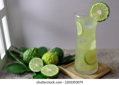 A Glass Of Fresh Bergamot Juice  On Wooden Coaster