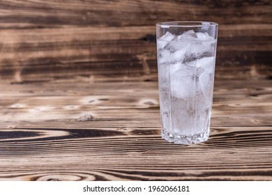 A Glass Of Fresh Seltzer Water With Ice On A Wooden Background. Space For Text