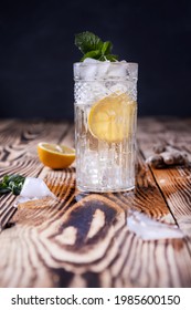 Glass Of Fresh Seltzer Water With Ice Lemon And Mint On A Wooden Background