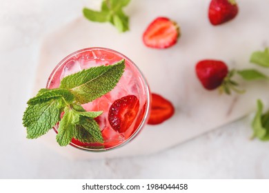 Glass of fresh strawberry mojito on light background - Shutterstock ID 1984044458