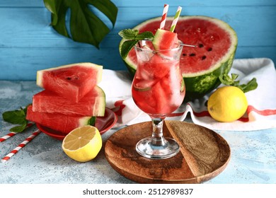 Glass of fresh watermelon lemonade with and palm leaf mint on blue table - Powered by Shutterstock