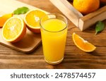 Glass of freshly squeezed orange juice on the table with citrus fruits