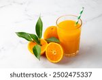 Glass of freshly squeezed orange juice on the table with citrus fruits