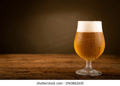 Glass full of cold beer on the wooden table - Powered by Shutterstock