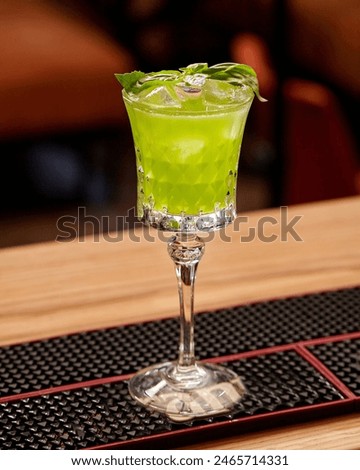 Glass of gin based Basil Smash cocktail on bar