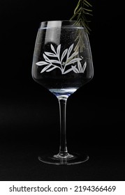 A Glass Of Gin And Tonic Cocktail With Rosemary Isolated On A Black Background