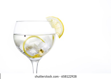 Glass Of Gin Tonic With Lemon On White Background