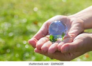 Glass globe in hand  in the grass concept for environment protection - Shutterstock ID 226906339