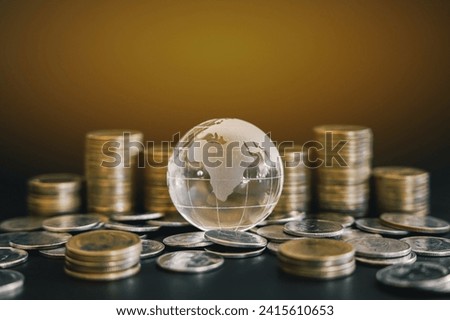 Glass globe on pile and stack of golden money coin. Business and financial concept background.