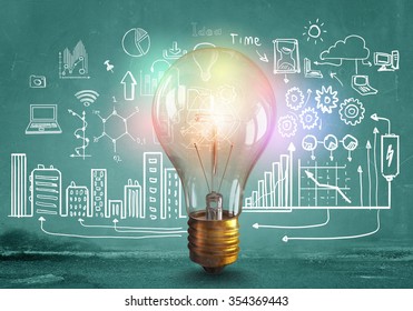 Glass glowing light bulb and business sketched ideas