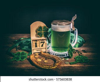 Glass of green beer and golden horseshoe for St. Patrick's Day