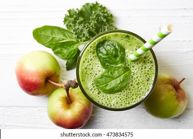 Glass Of Green Fruit And Vegetable Smoothie On White Wooden Background From Top View