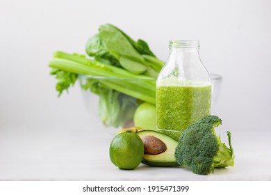 glass with green healthy smoothie, nutritious breakfast, vegetarian food, raw vegetables in the morning, broccoli, avocado, celery, salad, kiwi apple, lime. healthy eating for the whole family, diet