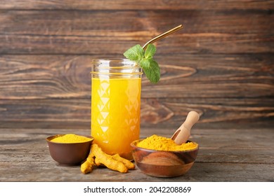 Glass Of Healthy Turmeric Drink On Wooden Background