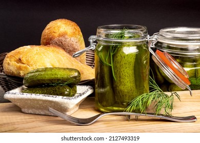 Glass Home Canning Jars Of Home Made Baby Dill Pickles On A Dark Wooden Pantry Shelf With Loaves Of French Bread