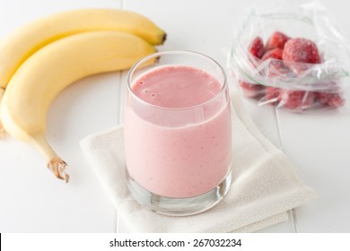 A Glass Of Homemade Banana And Frozen Strawberry Smoothie On White Background