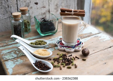 Glass Of Hot Indian Yoga Drink - Masala Chai Tea With Spices And Igredients On A Rustic Table