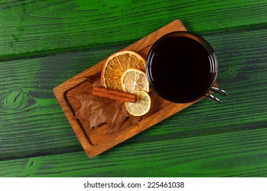 Glass Of Hot Mulled Wine With Cinnamon And Citrus Slice On Wooden Board Top View