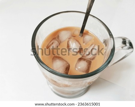 A glass of ice Goodday freeze segar with spoon stirrer , accompany you in the hot atmosphere of the city of Surabaya East Java - Indonesia , white table background in the living room. 