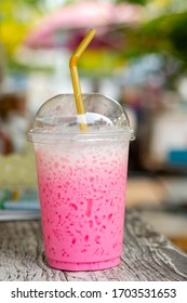 Glass of ice pink milk with straw