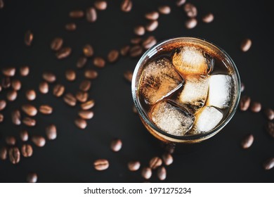 Glass Of Iced Americano Coffee On Black Background With Coffee Beans 