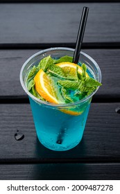 glass of Iced blue hawaii soda on table, blue curacao lemonade with orange and mint. Water drinking Blue Cocktail drink with ice, Blue Lagoon Cocktail