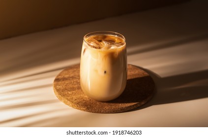 Glass of a iced coffee with cream milk. Cold brew coffee drink with ice. Early morning sun light.  - Shutterstock ID 1918746203