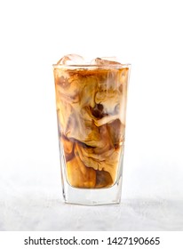 Glass Of Iced Coffee With Milk On White Wooden Table