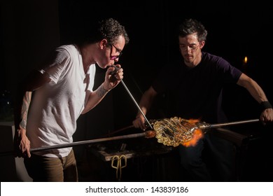 Glass industry artists working with blowpipe and blowtorch - Powered by Shutterstock