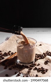 A Glass Of Irish Cream Coffee Liqueur With Ice And Ice. Coffee Beans, Black Bottle.