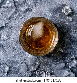 Glass Of Irish Whiskey With Ice Over Dark Texture Background. Top View, Flat Lay. Copy Space