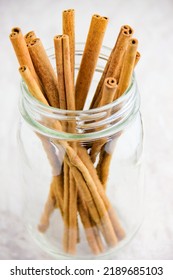 Glass Jar Of Cinnamon Sticks Set On A White Background