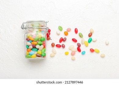 Glass jar with different jelly beans on light background - Powered by Shutterstock