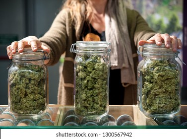 Glass jar full of Cannabis Sativa for sale at a market stall.