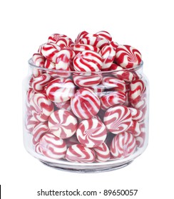 Glass jar full of red striped caramel sweets isolated on white background