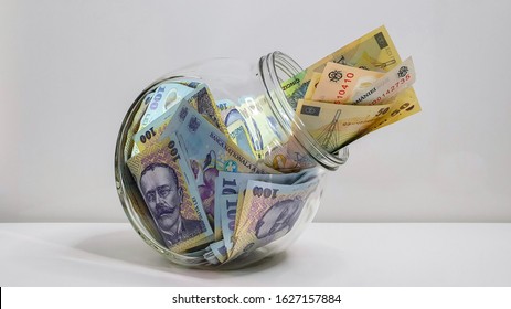 Glass Jar Full Of Romanian RON Bank Notes On A White Background