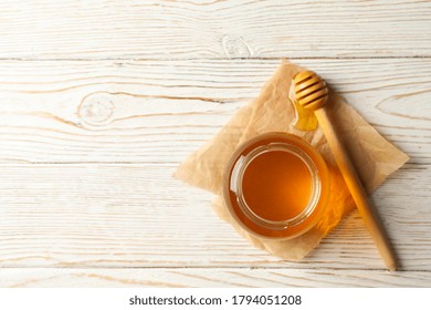 Glass Jar Of Honey And Dipper On White Wooden Table, Top View