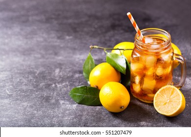 Glass Jar Of Iced Tea With Fresh Lemons On Dark Background.