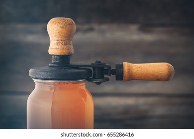 Glass Jar Of Juice And Retro Can Lid Closing Machine For Canning.