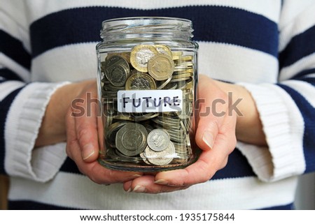 A Glass Jar Labelled Future Full Of Money. Holding Your Future In Your Hands Concept.