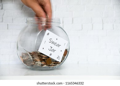 Glass Jar On A White Shelf In A Household Living Room. Swear Box Concept