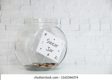 Glass Jar on a white shelf in a household living room. Swear box Concept