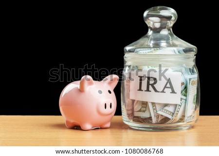 glass jar used for saving US dollar bills and notes for IRA retirement fund