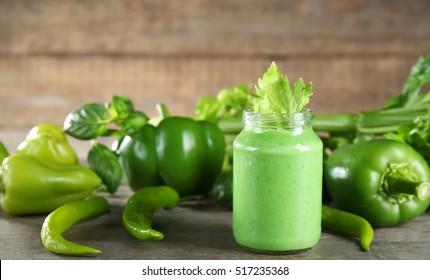 Glass jar with vegetable smoothie on wooden table - Shutterstock ID 517235368
